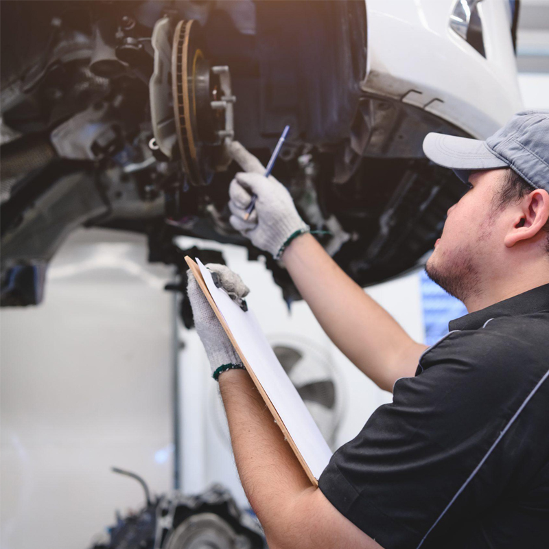 man inspecting brakes on a car