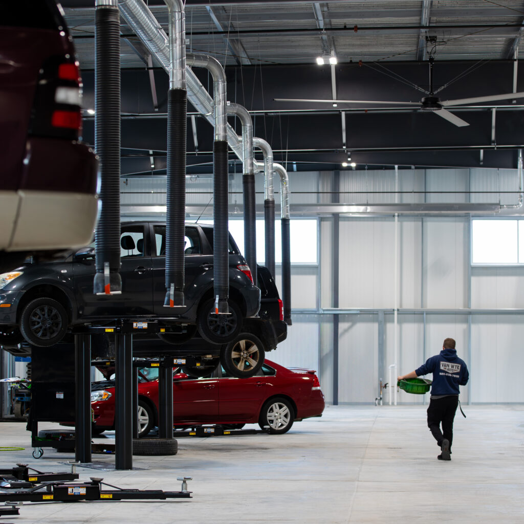 Person walking through Van Wyk Auto’s mechanic shop toward service bays