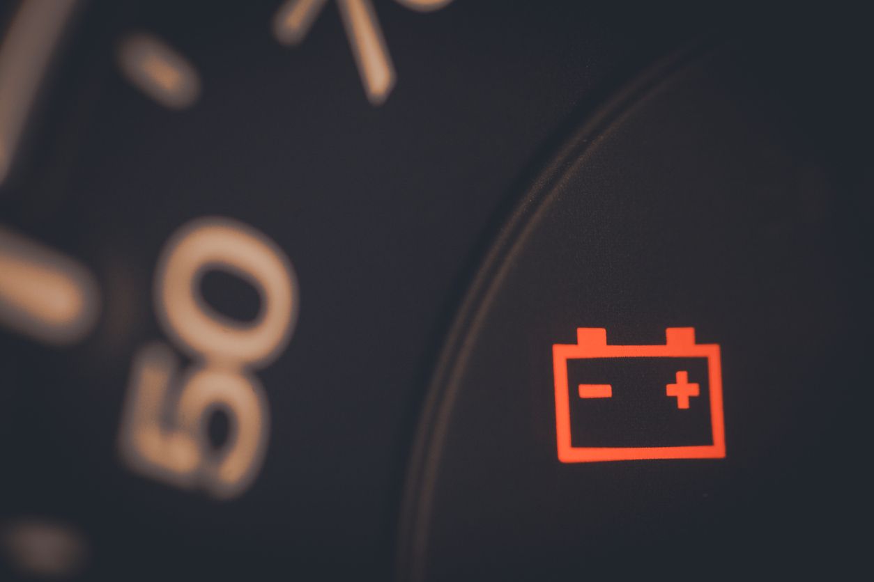 Battery warning light illuminated on a vehicle dashboard